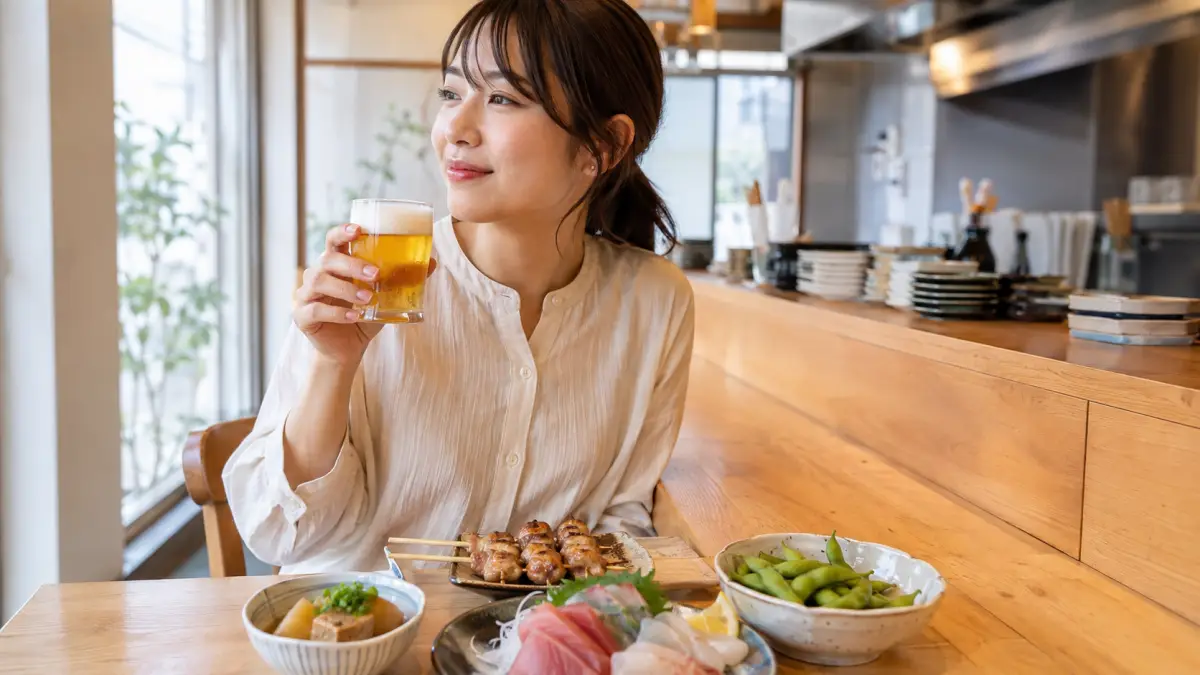 六本松で一人昼飲みを楽しむ女性 六本松の居酒屋で一人昼飲みを楽しむ若い日本人女性