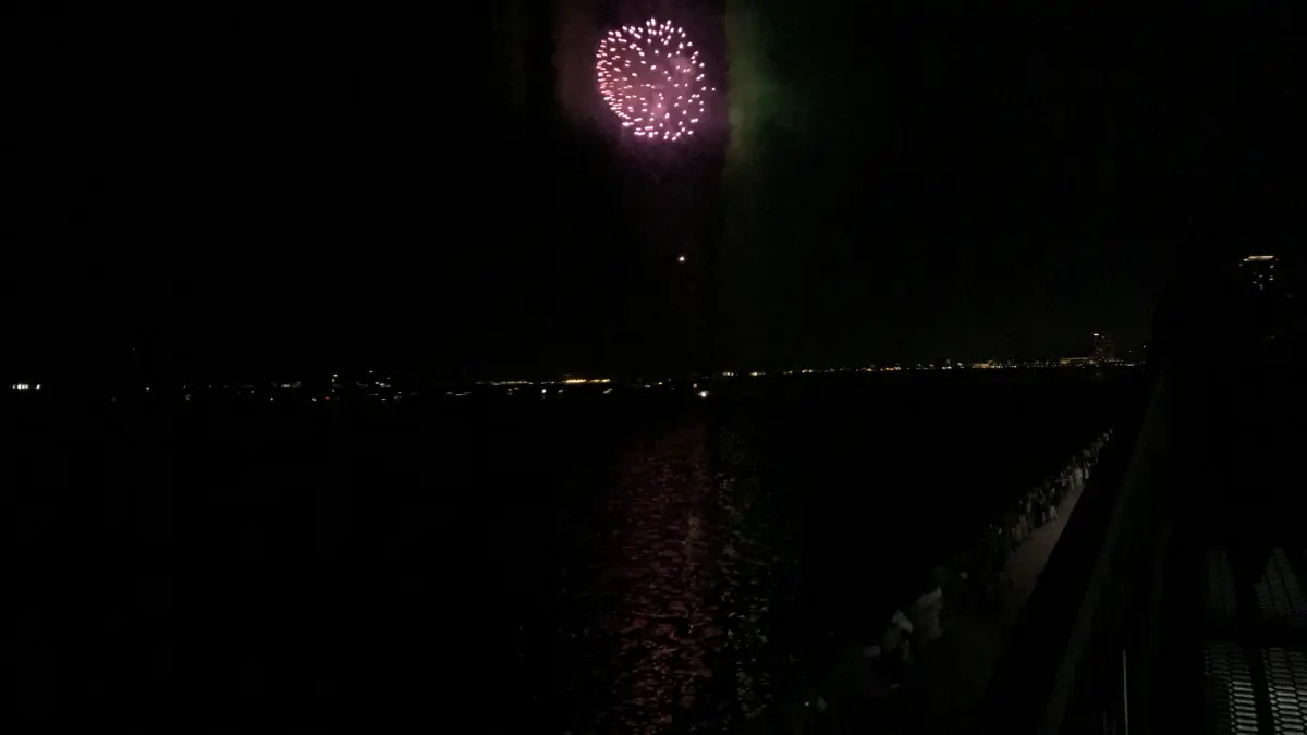 海辺から見た姪浜花火大会の花火と水面に映る光の様子