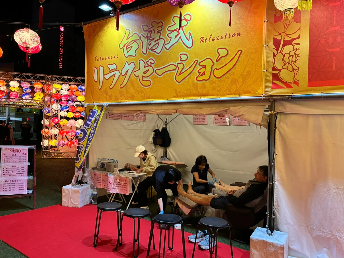 台湾祭会場の台湾式リラクゼーションブースで足つぼマッサージを受ける来場者